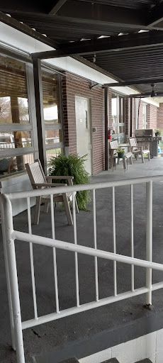 A cozy outdoor seating area with chairs and plants, providing a welcoming space outside a building.
