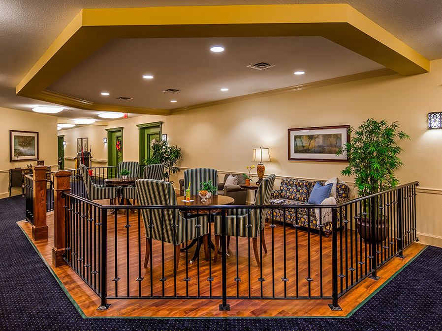 A cozy seating area featuring comfortable chairs, a sofa, and a table, complemented by plants and warm lighting.