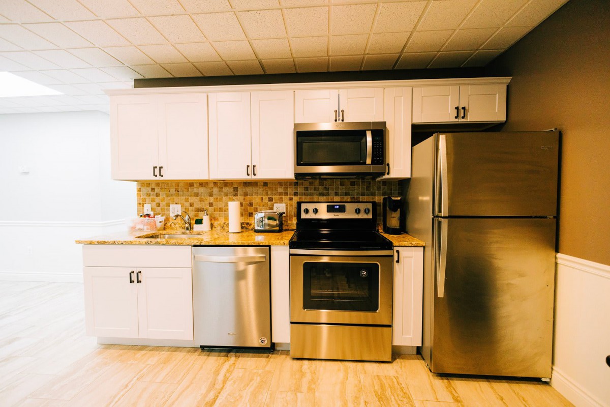 A modern kitchen with white cabinets and stainless steel appliances.