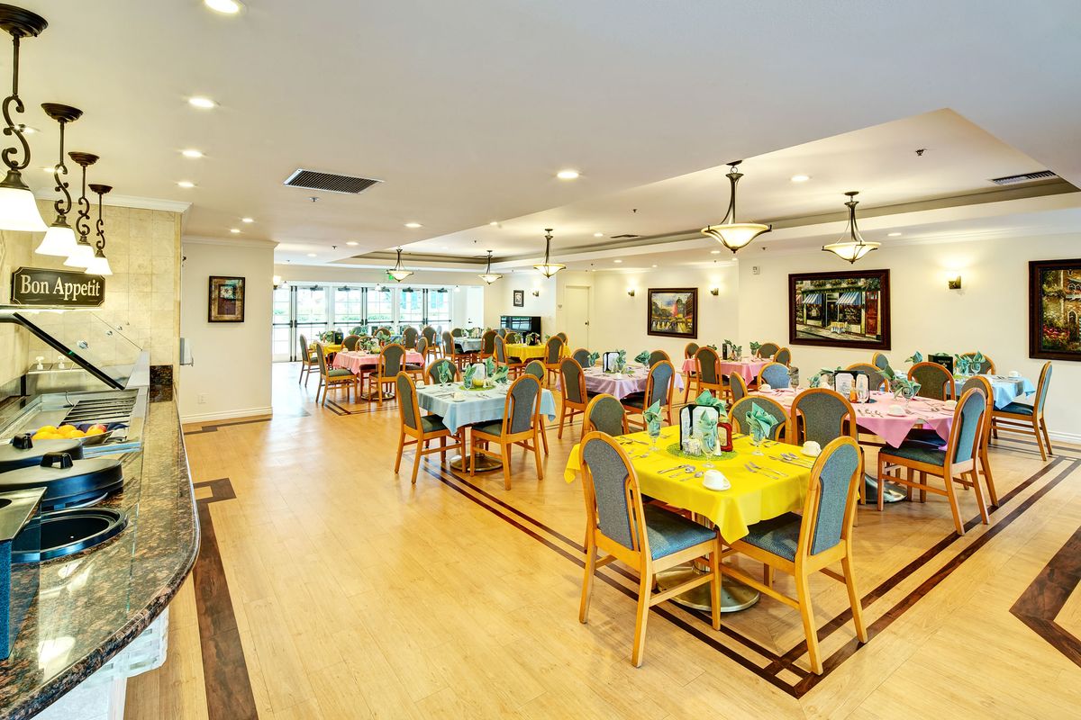 A spacious dining area with colorful table settings and bright lighting.
