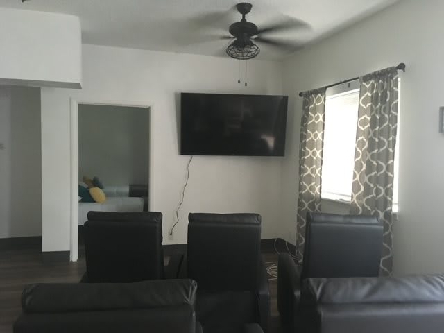 A cozy living room setup with a wall-mounted television and comfortable seating.