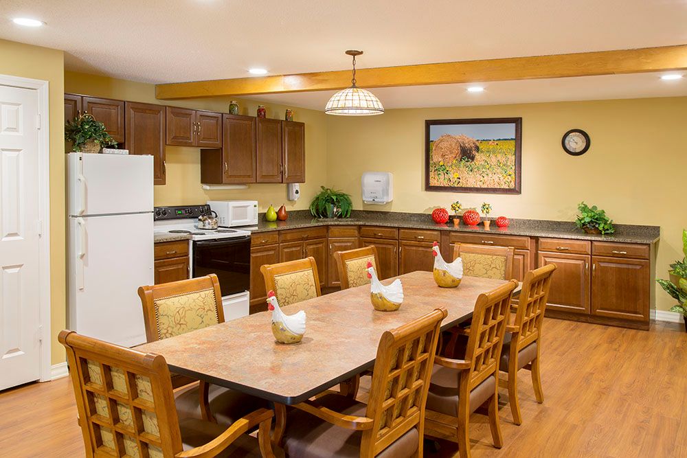 A cozy kitchen and dining area with wooden cabinets, a large table, and modern appliances.