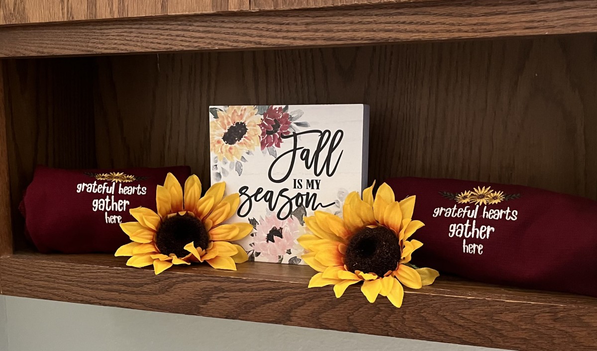 Autumn-themed shelf with sunflowers and a 'Fall is my season' sign.