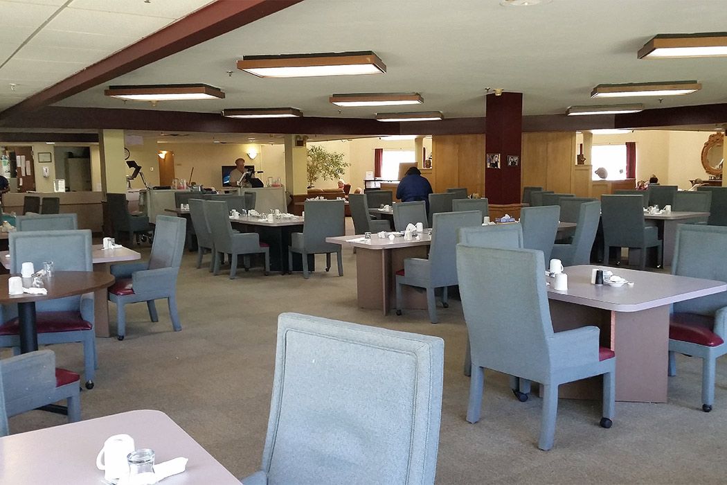 A spacious, modern restaurant interior with neatly arranged tables and chairs.