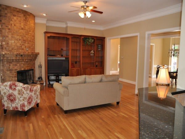 A cozy living room with wooden floors, a sofa, and a television.