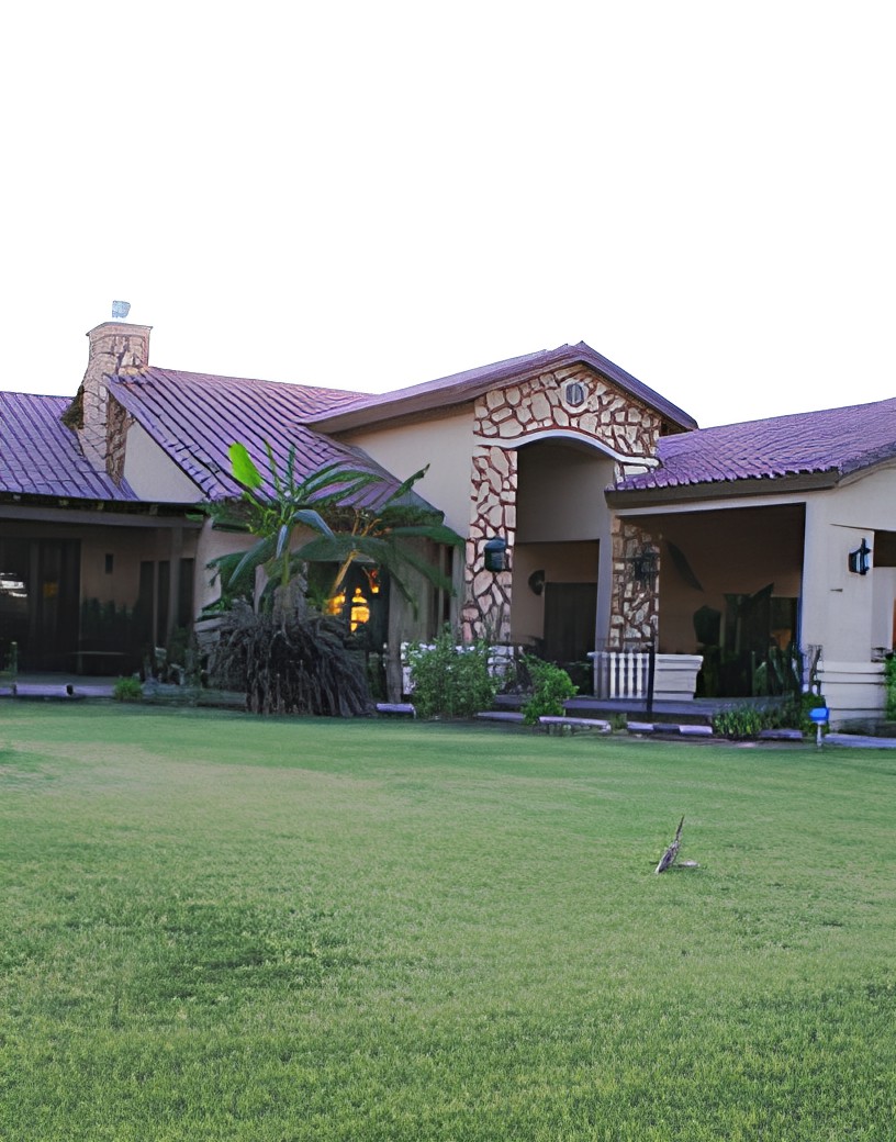 A beautiful residential house with a spacious lawn and stone accents.