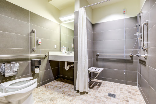 An accessible bathroom featuring a shower, sink, and safety amenities for ease of use.