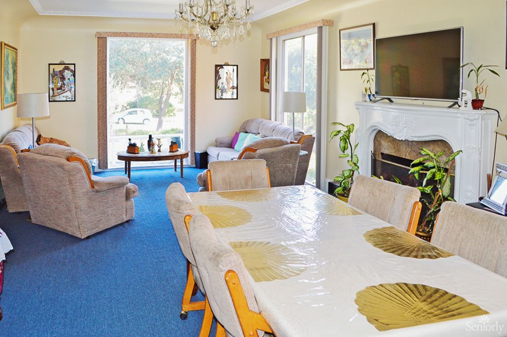 A spacious living room with a dining table, cozy seating, and a fireplace.