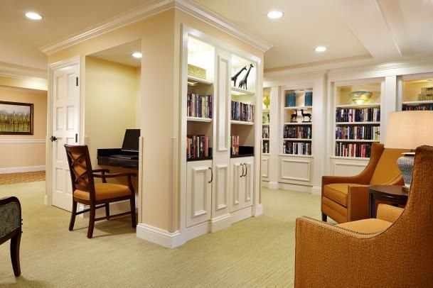 A cozy library room with bookshelves and comfortable seating.