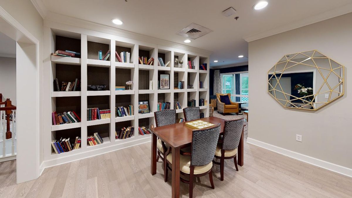 A cozy library space with bookshelves, a table, and chairs for reading or studying.