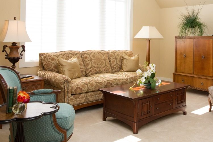 A cozy living room with a patterned sofa, wooden coffee table, and classic decor.