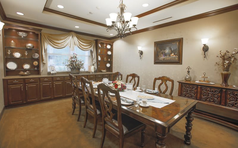 A traditional dining room with elegant wooden furniture and a classic chandelier.