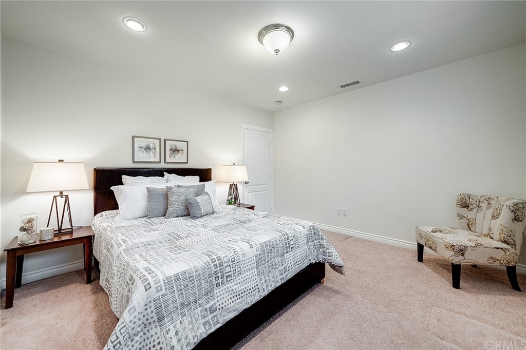 A modern, minimalist bedroom with a neatly made bed and elegant decor.