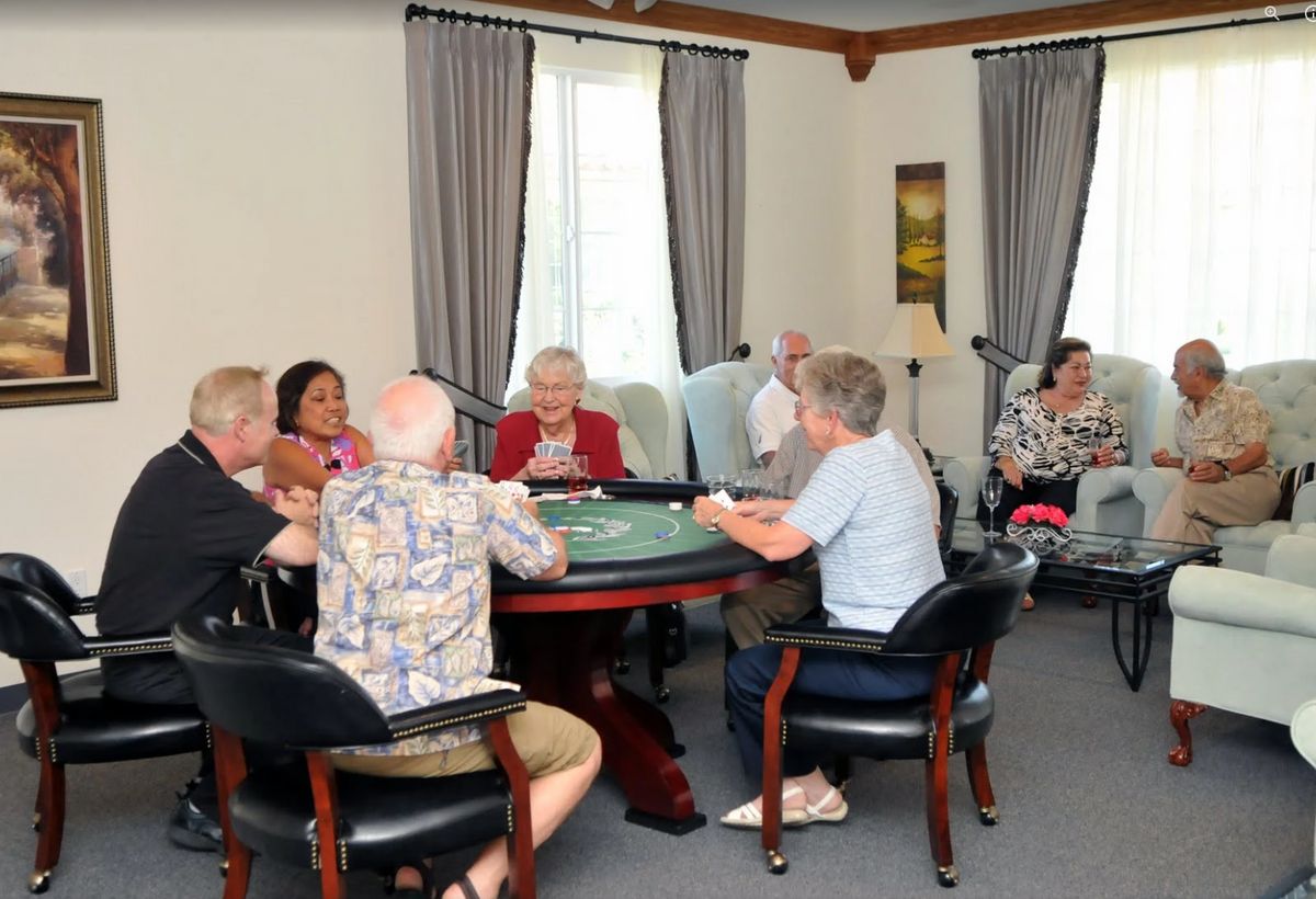 A group of seniors enjoying a card game in a comfortable indoor setting.