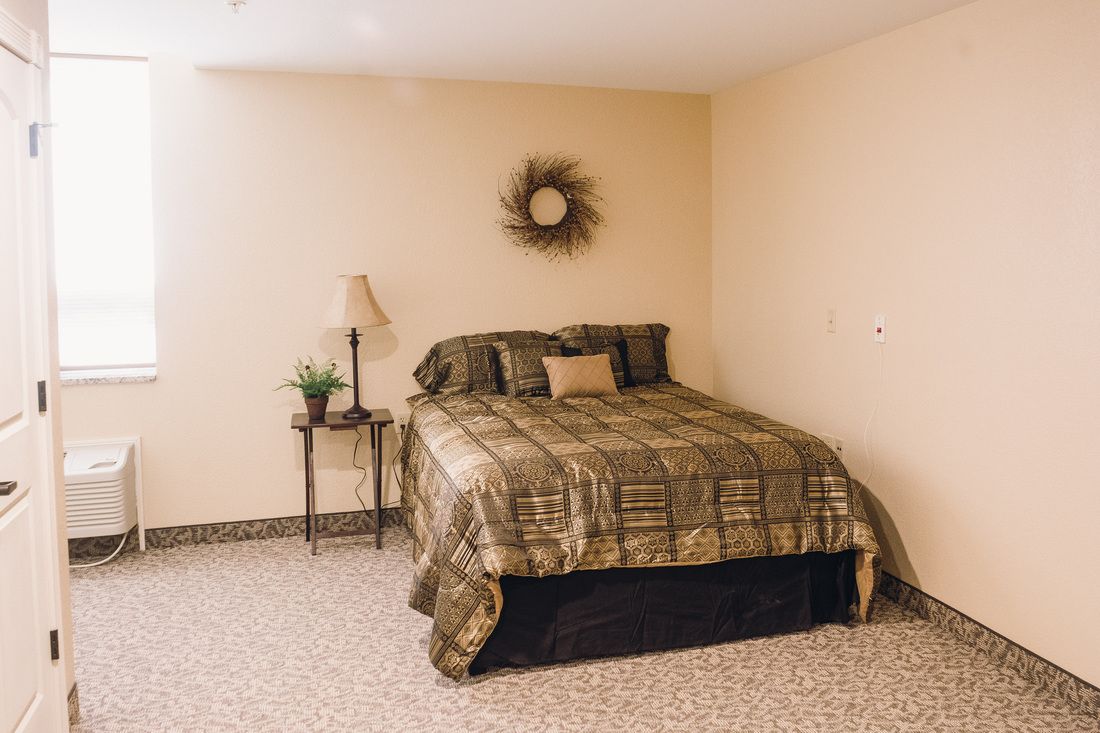A cozy bedroom with a neatly made bed, decorative pillows, and complementary wall decor.
