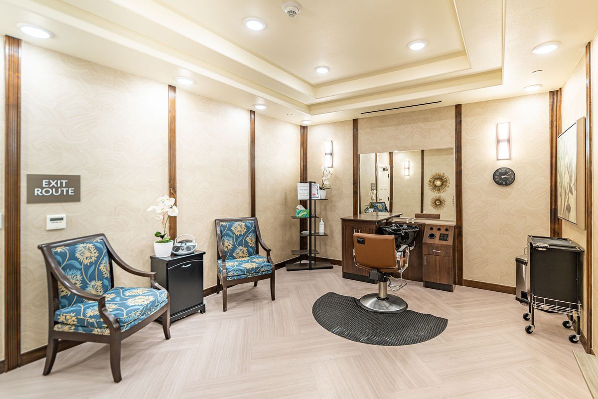 A well-lit hair salon with stylish chairs and a mirror station.