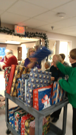 A festive gathering where volunteers wrap gifts for the holiday season.