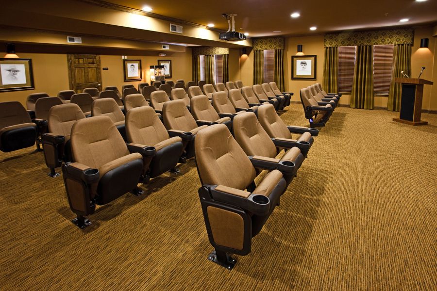 An empty theater auditorium with rows of comfortable seating.