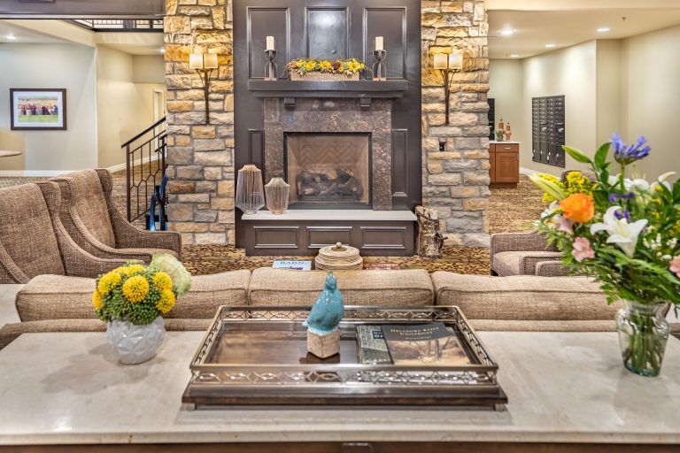 A cozy living room featuring a stone fireplace, stylish decor, and comfortable seating.