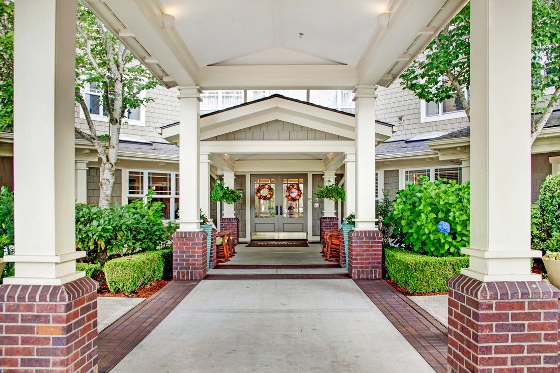 A welcoming entrance to a building with decorative columns and plants.