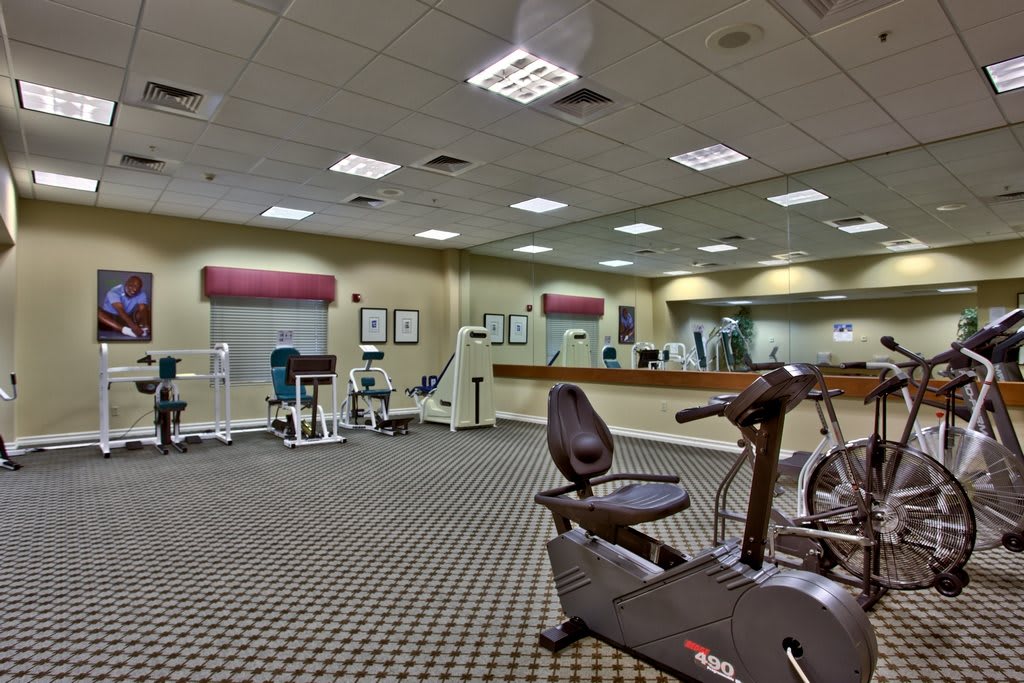 Spacious gym with various exercise equipment including stationary bikes and treadmills.