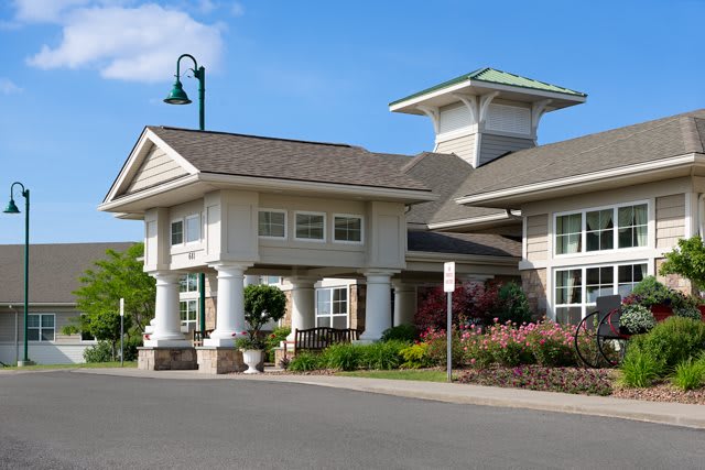 Modern residential building with landscaped surroundings and clear blue sky.