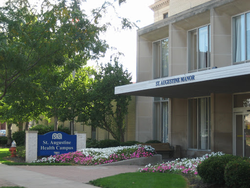An exterior view of a building with landscaped gardens and clear signage.