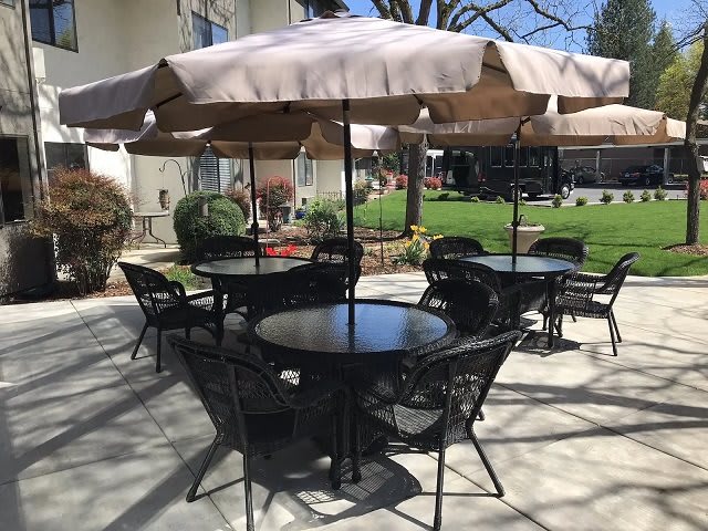 An outdoor patio area with tables, chairs, and umbrellas.