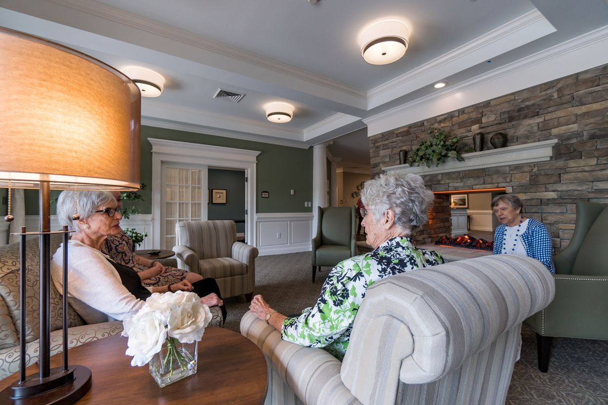 A group of people sitting and conversing in a comfortable lobby area.