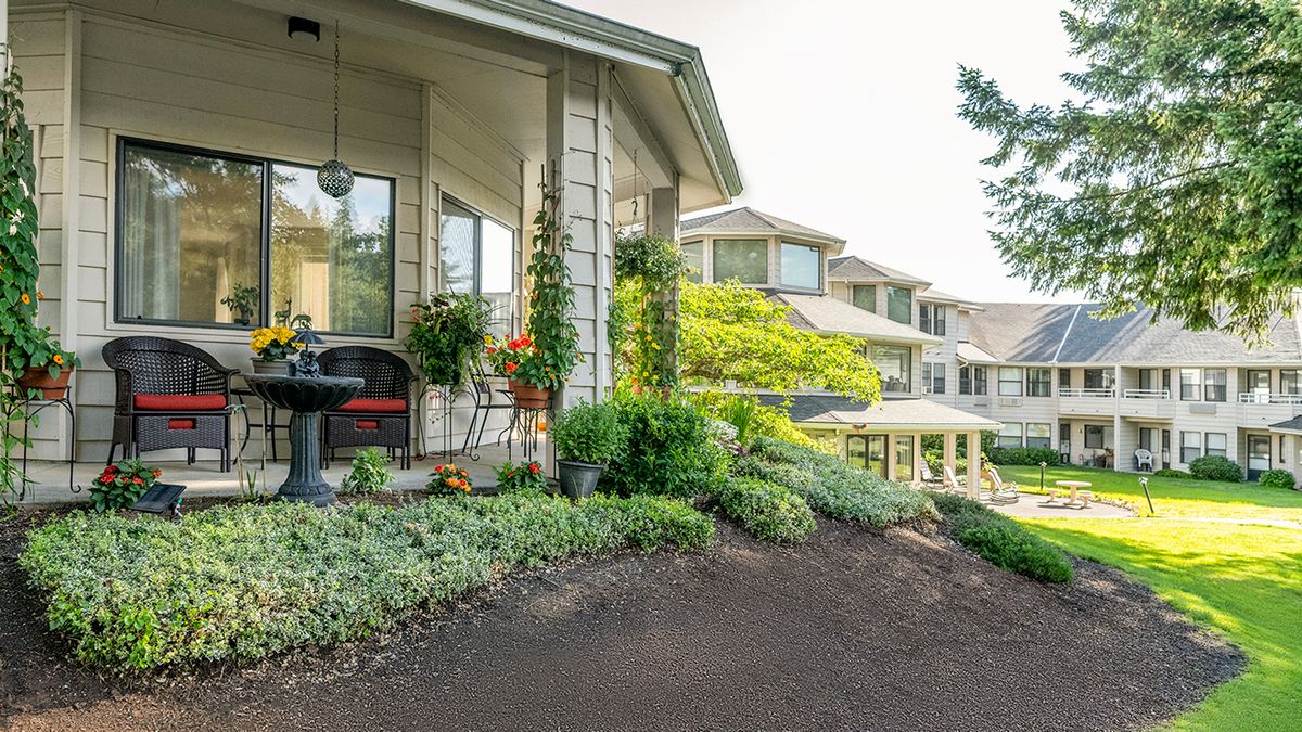 A beautiful house with a lush garden and cozy porch area.