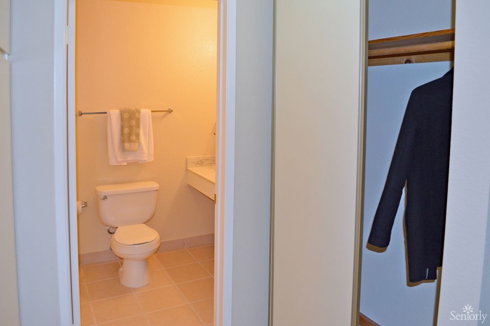 A view of a clean bathroom with a toilet, sink, and towel.