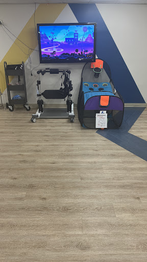 A pet play area featuring a multicolored pet carrier, a storage cart, and a television in the background.