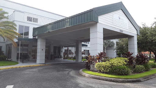 A modern building entrance surrounded by well-maintained landscaping.