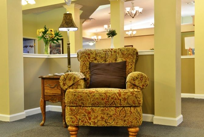 A cozy living room setting with a patterned armchair and side table.