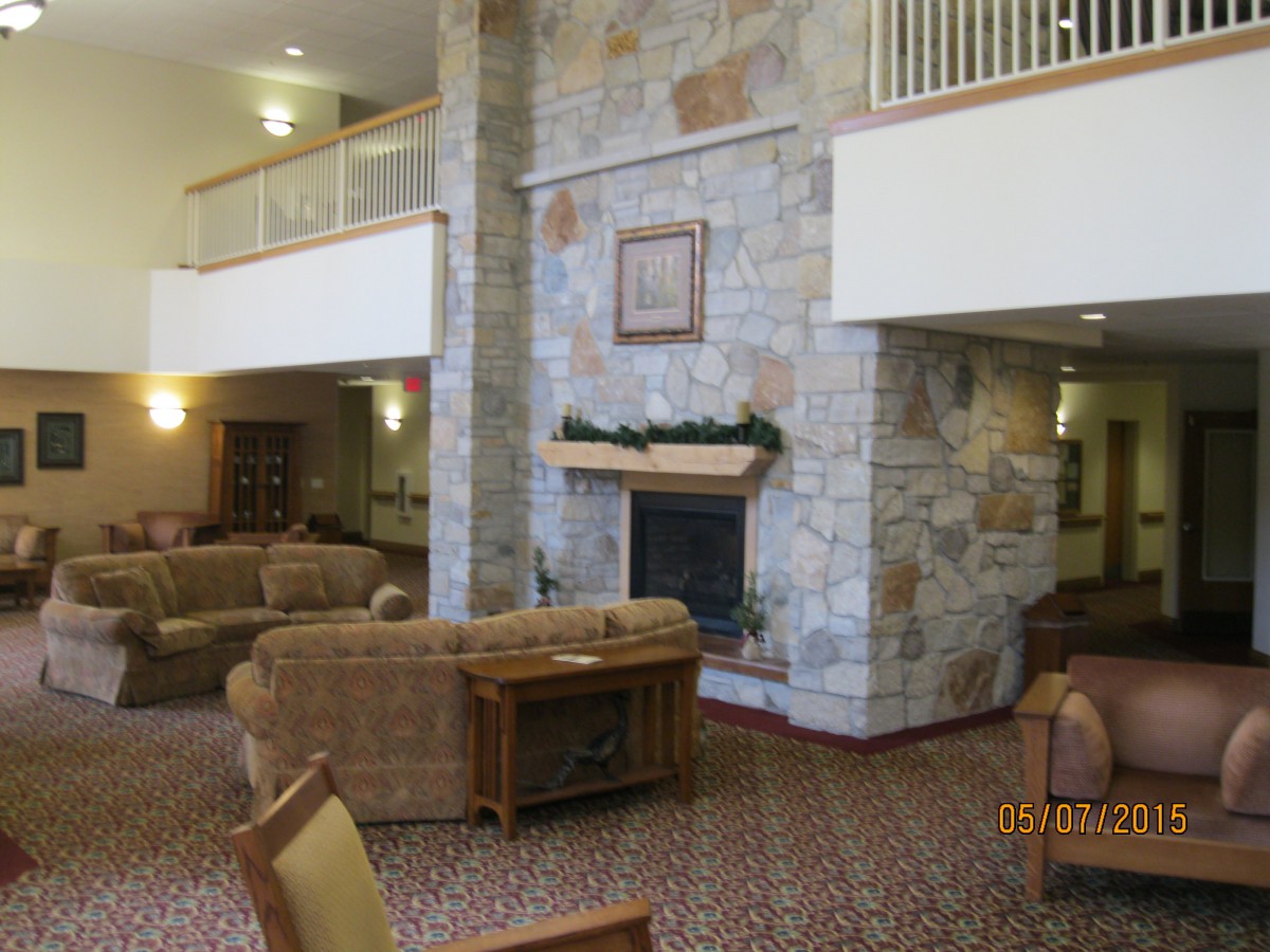 A spacious lobby with comfortable seating and a stone fireplace.