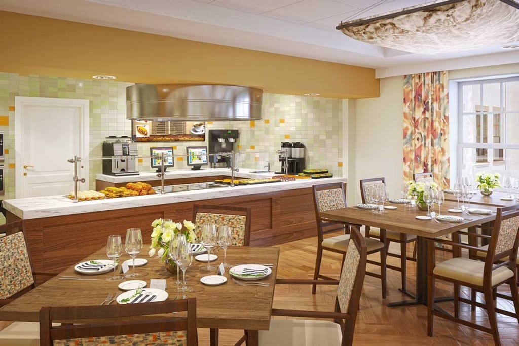 A cozy dining area with elegantly set tables and a view of the kitchen.