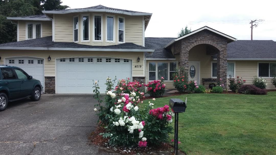 A residential house with a well-maintained garden and driveway.