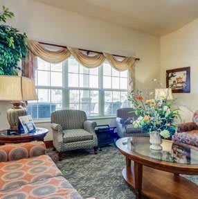 A cozy living room with comfortable seating, a coffee table, and large windows letting in natural light.