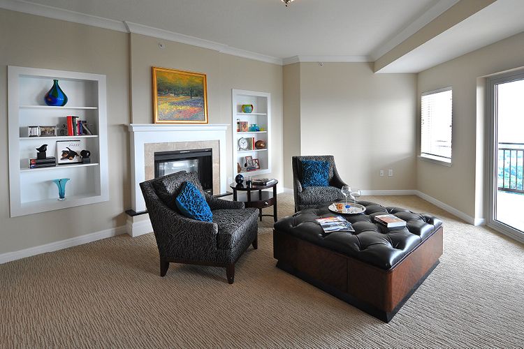 A modern living room featuring comfortable seating, a fireplace, and decorative artworks.