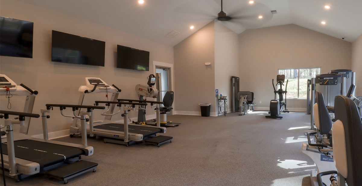 A spacious gym with various exercise machines and equipment.