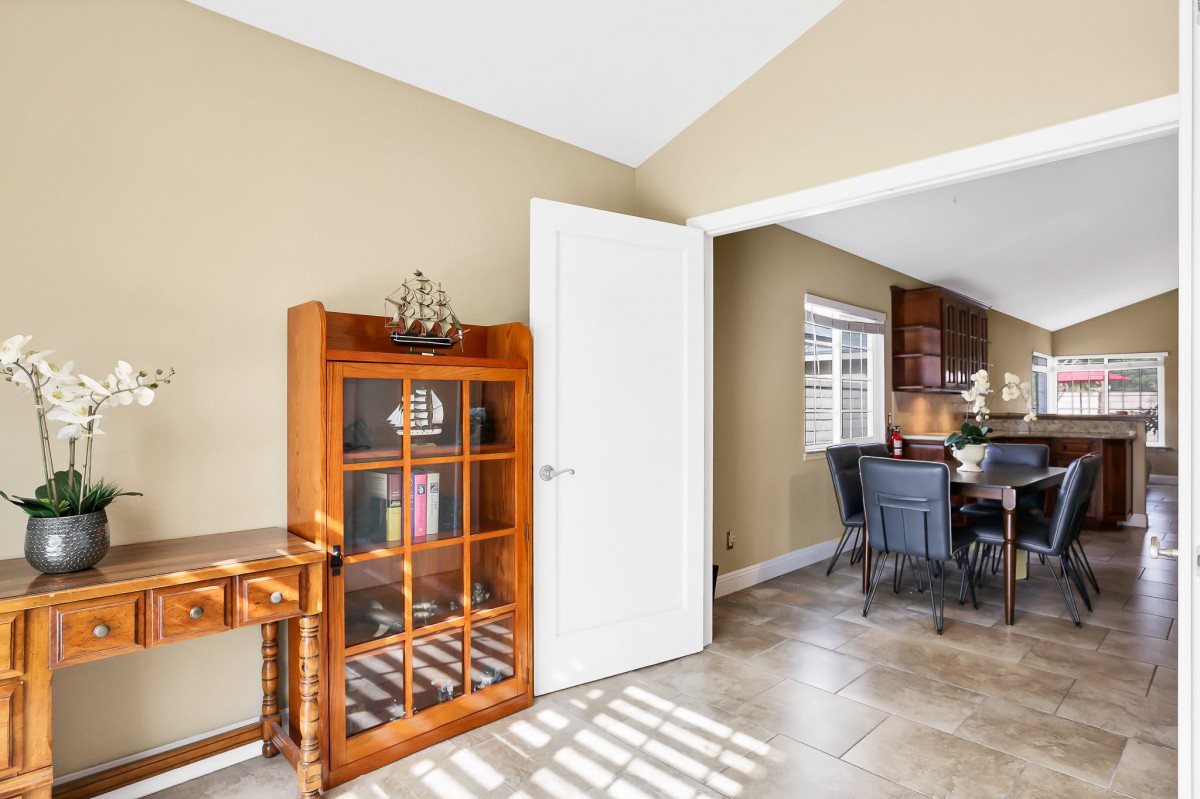 A cozy living space featuring a wooden cabinet and an open doorway leading to a dining area.