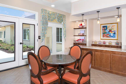 A cozy dining area with a round table and four chairs, featuring natural light and elegant decor.