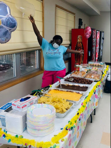 A vibrant celebration with a delicious spread of snacks and desserts, featuring a joyful participant enjoying the moment.