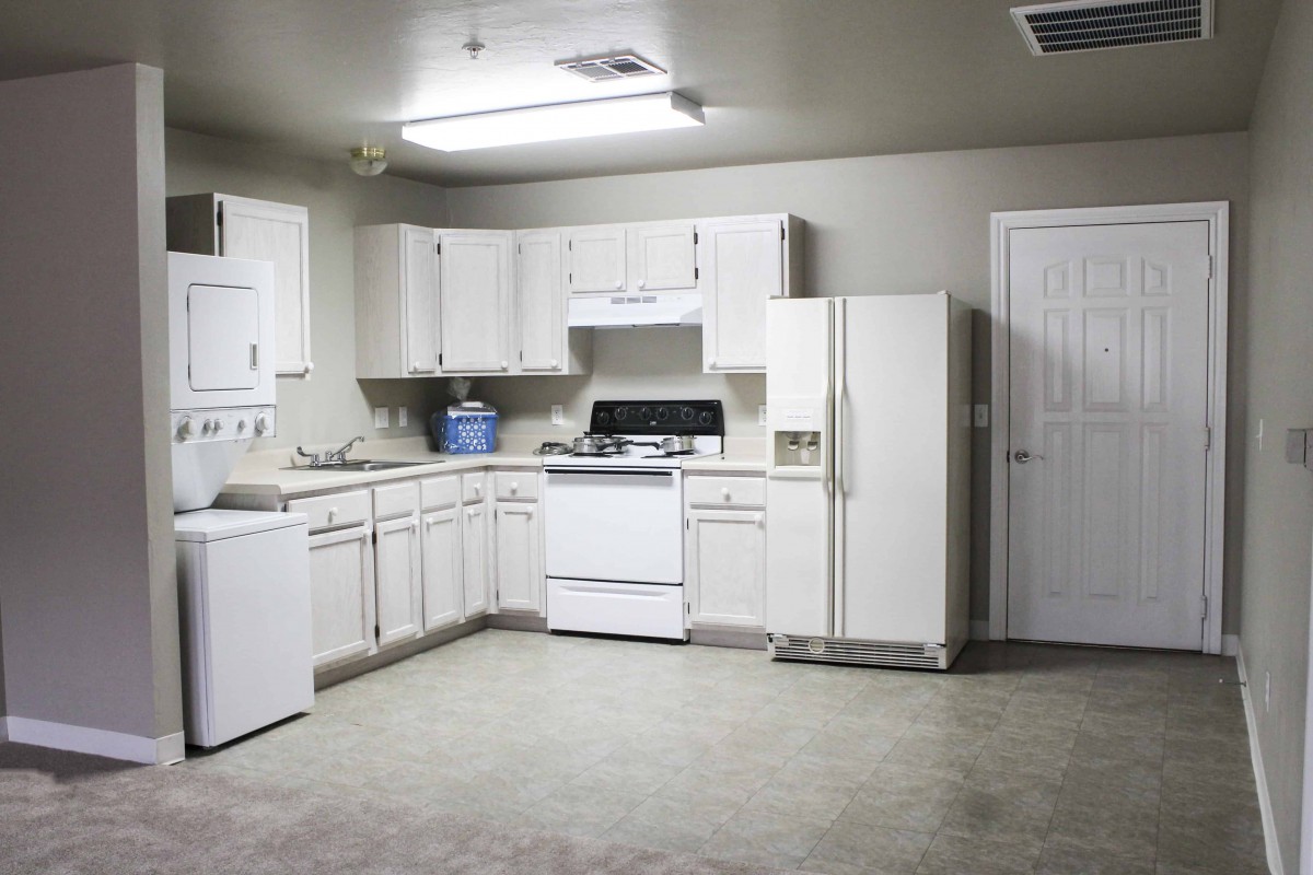 A modern kitchen with white cabinets and appliances.