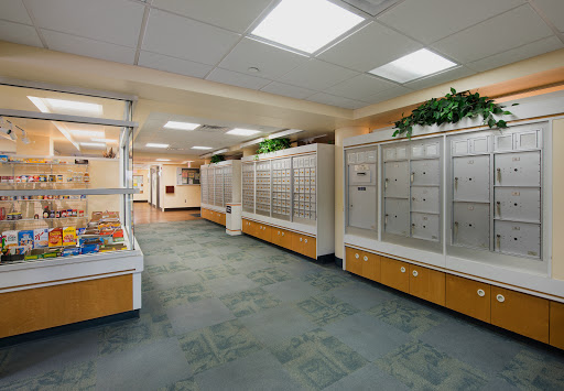 A well-lit interior hallway featuring mailboxes and modern furnishings.