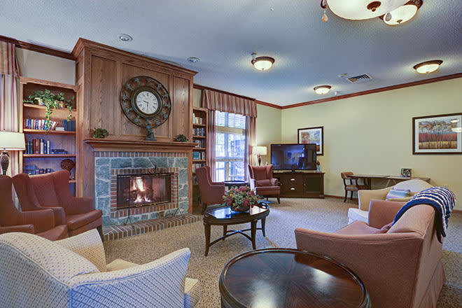 A cozy living room with a fireplace, comfortable seating, and a television set.