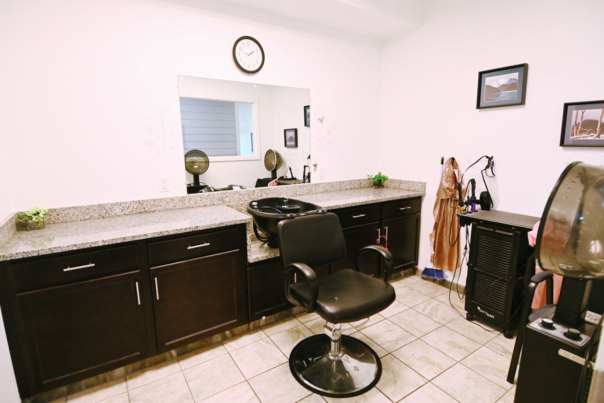 A well-organized hair salon station with a barber chair and mirror.