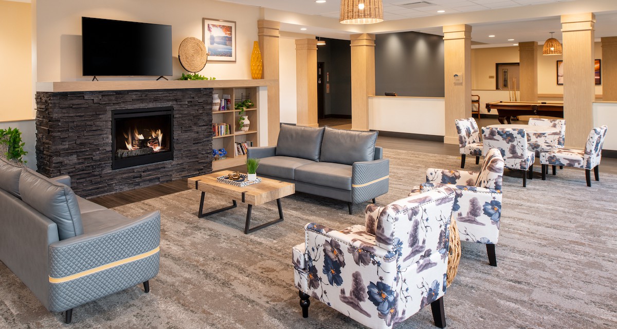 A modern lobby area featuring comfortable seating and a cozy fireplace.