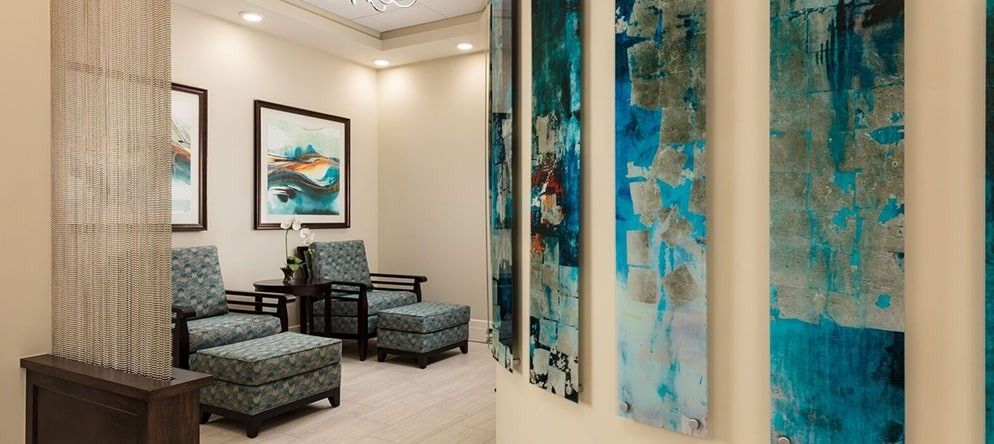 A modern waiting room featuring abstract artwork and comfortable seating.