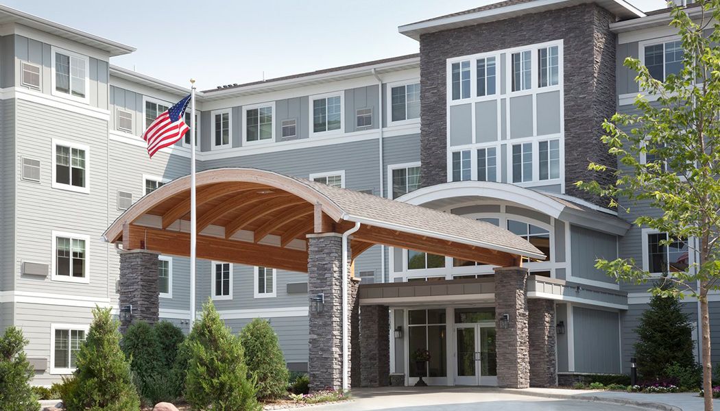 A modern building with a prominent entrance and an American flag.